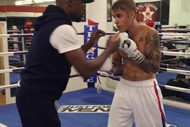 CELEBRITY SHOWDOWN?: Singer Justin Bieber (above right) once traded punches with boxing champion Floyd Mayweather Jr (left) in a ring. But that training was for fun. The singer is in good shape physically, but can he go the distance in a real, compet