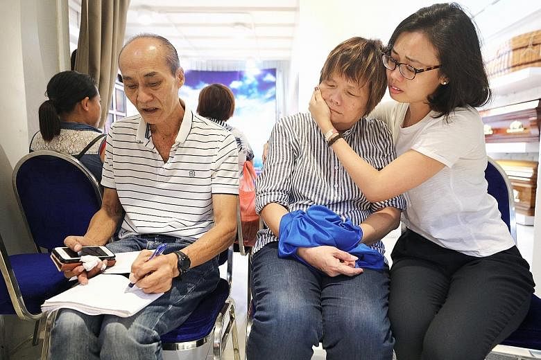 Mr Tung, who worked at rooftop bar 1-Altitude, fell into a 4m-deep pit on the roof of One Raffles Place and died. Security guard Shaun Tung's father Tung Kim Swee, mother Chan Lian Poh and sister Rebecca at his wake in Geylang Bahru.