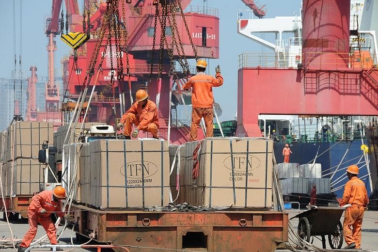 Workers loading goods for export onto a crane at a port in Jiangsu province in China. The WTO saw 24 dispute settlement cases last year specifically related to the US-China trade war - on issues like intellectual property - said WTO director for info