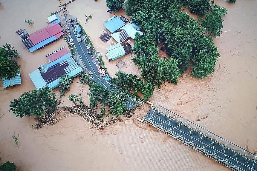 A pickup truck making its way through a flooded village in Andadowi in South-east Sulawesi on Tuesday. Below is a handout picture released by Indonesia's accident mitigation agency showing an aerial view of the village. PHOTOS: AGENCE FRANCE-PRESSE