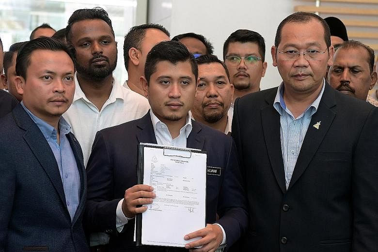 Economic Affairs Minister Azmin Ali's political secretary Hilman Idham holding up a copy of the police report he made yesterday. He had asked the police to investigate the sex videos purportedly showing Malaysian government official Muhammad Haziq Ab