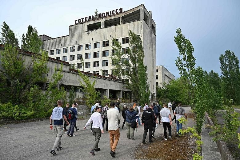 Above: A tourist in Chernobyl taking a selfie. Right: Visitors in the ghost town of Pripyat during a tour of the Chernobyl exclusion zone last week. PHOTOS: SEREGASTRANGE/INSTAGRAM, AGENCE FRANCE-PRESSE