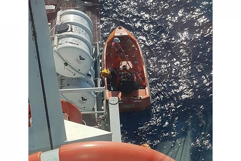 Mr Low in the Diogo Cao's rescue boat with some of the ship's crewmen. First Officer Srdan Bazdan had spotted a bright orange ring buoy floating about 1km away and when the ship neared, they found Mr Low. The RSAF Rescue 10's Aircrew Specialist Nicol