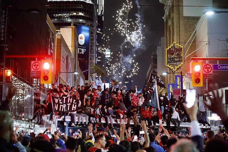 Toronto Raptors fans celebrate atop a bus after their team beat the Golden State Warriors in Game 6 of the NBA Finals to clinch their maiden title on Thursday night.