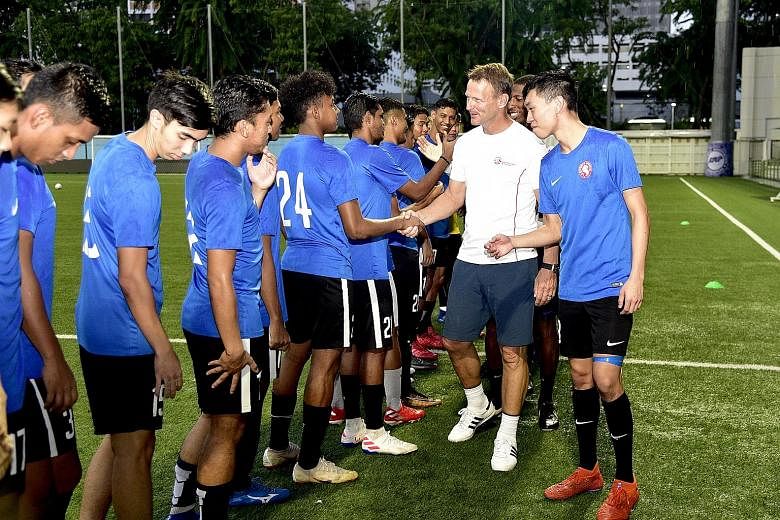 Former Tottenham and Manchester United striker Teddy Sheringham being introduced to the Young Lions by their captain Joshua Pereira at Jalan Besar Stadium on Thursday. 
