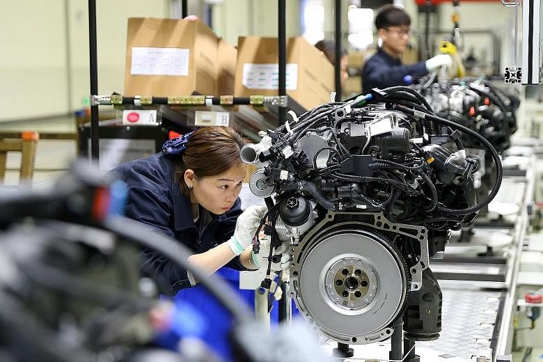 An employee at an automotive engine factory in China's Sichuan province. Industrial output grew 5 per cent last month from a year earlier, missing analysts' expectations of 5.5 per cent. PHOTO: REUTERS