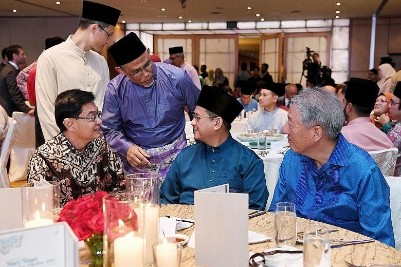 Minister-in-charge of Muslim Affairs Masagos Zulkifli (in purple) with (seated, from left) Deputy Prime Minister Heng Swee Keat, Mufti Fatris Bakaram and Senior Minister Teo Chee Hean at a Hari Raya get-together for community and religious leaders ye