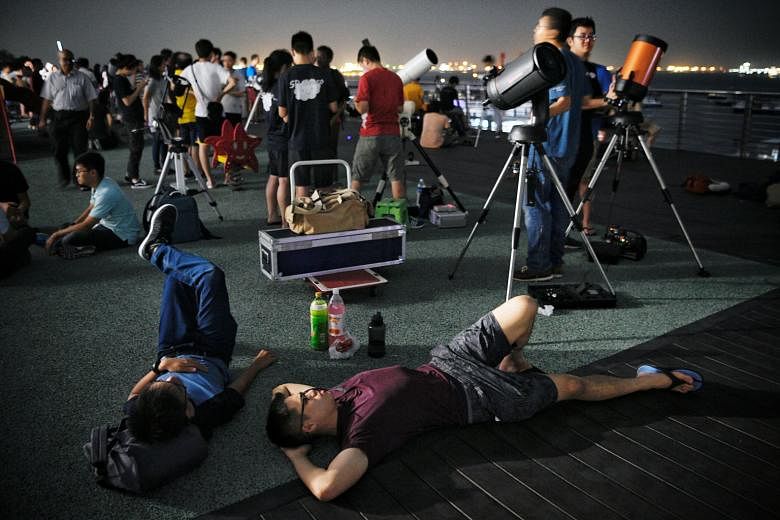 People on the roof of the Singapore Maritime Gallery on July 27 last year waiting to witness a total lunar eclipse. For the annular solar eclipse on Dec 26, the best view of the phenomenon is from the southern part of Singapore.