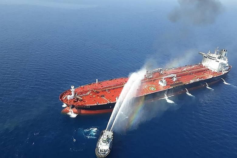 A picture from Iran's Tasnim News Agency showing an Iranian navy boat trying to control fire on the Norwegian-owned Front Altair which was attacked in the waters of the Gulf of Oman last Thursday. The US has accused Teheran of carrying out the attack
