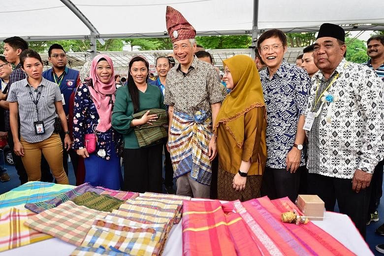 Prime Minister Lee Hsien Loong at Karnival Aidilfitri yesterday with fellow Ang Mo Kio GRC MPs (from fourth left) Intan Azura Mokhtar and Gan Thiam Poh. With them was Madam Noriani Osman (far left), the carnival's organising chairman. The event, held