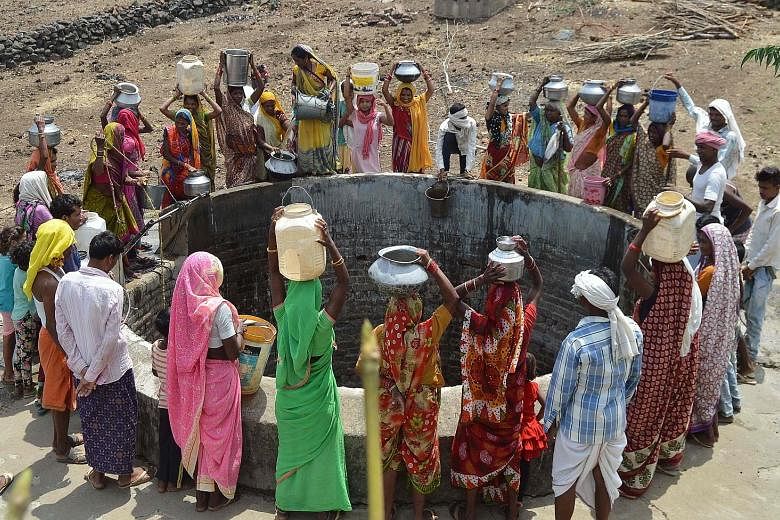 Indian villagers in Madhya Pradesh state collecting drinking water at a well. The severe heat in Bihar state, which reached 46 deg C in some areas, has also caused some schools to be ordered closed. State health officials have appealed to people to a