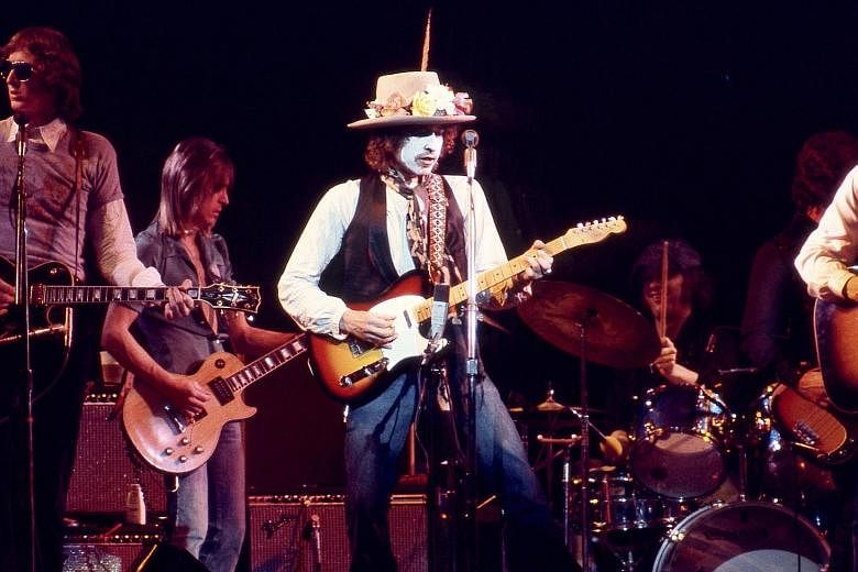 Singer Bob Dylan in white face paint, playing on the Rolling Thunder Revue tour, in the Netflix documentary.
