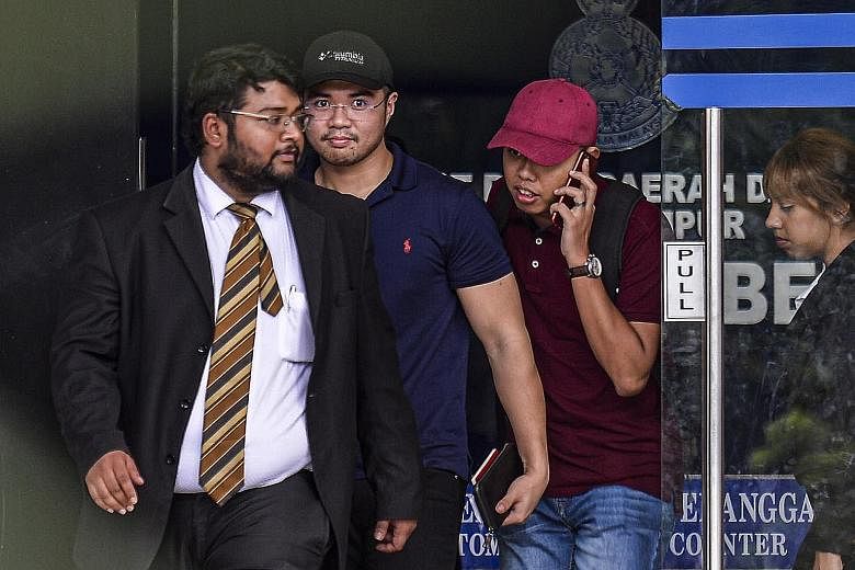 Mr Haziq Aziz (second from left), a PKR youth chief from Santubong in Sarawak, leaving a police station in Kuala Lumpur. He will be given 14 days to reply the show-cause letter.