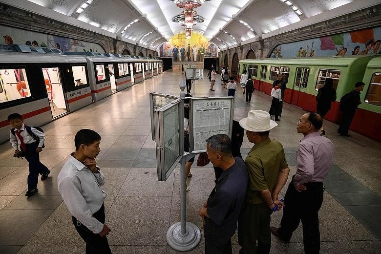 Commuters in a Pyongyang subway station, ahead of Chinese President Xi Jinping's state visit today to mark the 70th anniversary of diplomatic relations between China and North Korea. PHOTO: AGENCE FRANCE-PRESSE