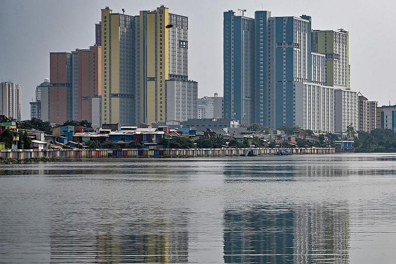 A slum area in Jakarta, dwarfed by high-rise buildings. Indonesian Finance Minister Sri Mulyani Indrawati has said the government's 5.3 per cent growth target may not be achieved. Analysts say fiscal stimulus may be more effective at keeping Indonesi