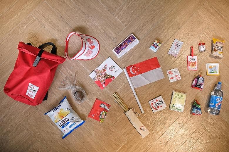 Left: The items in this year's NDP fun packs include reusable items such as bamboo straws that double as clappers and a 750ml water bottle, as well as NDP staples such as face tattoos and a miniature flag. Below: The bags come in red or white and fea