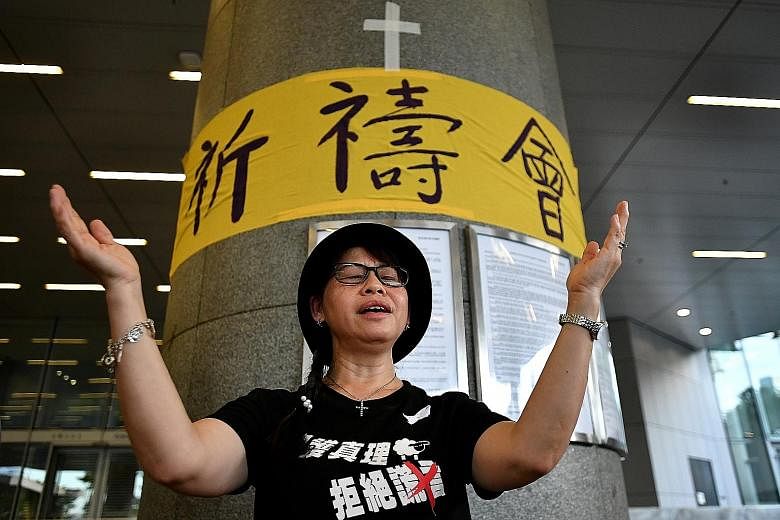 A protester singing Sing Hallelujah To The Lord at the Legislative Council Complex yesterday. The hymn has caught on quickly for its simple tune and lyrics, and is constantly being sung across protest sites.