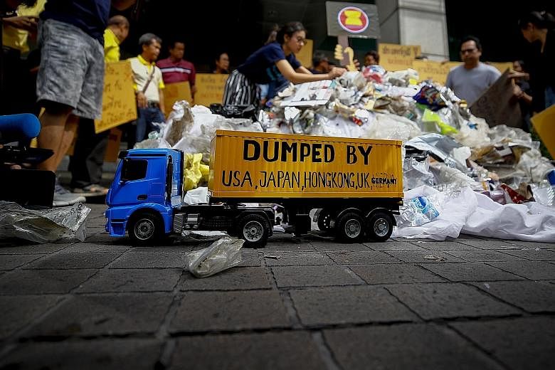 Greenpeace activists in Thailand staging a protest in front of the Ministry of Foreign Affairs in Bangkok, where they dumped plastic waste and held placards calling for an end to all trash imports to South-east Asia. After China's decision last year 