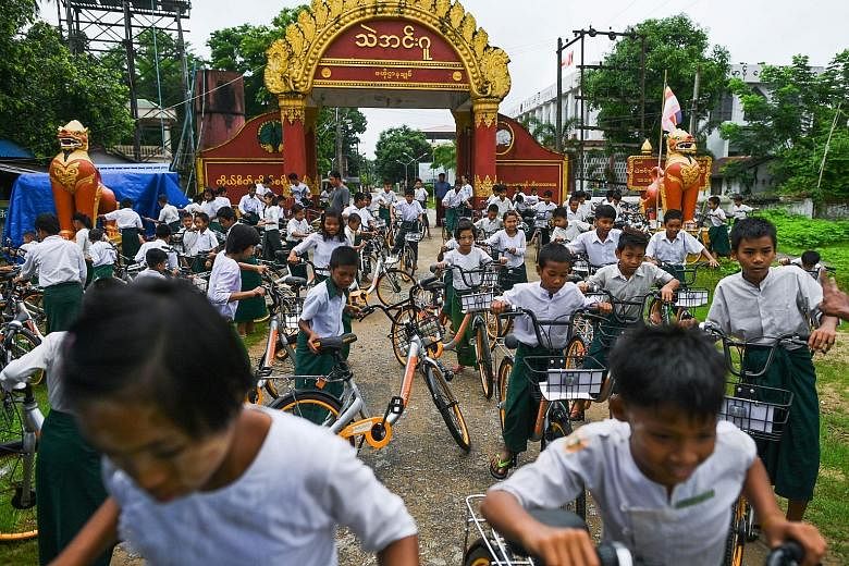 Myanmar children on bicycles - donated under the Lesswalk scheme that aims to give them easier access to education - in the compound of a Buddhist monastery on the outskirts of Yangon on Tuesday. The bicycles were previously used by bike-sharing comp