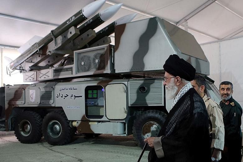 Iran's Supreme Leader, Ayatollah Ali Khamenei, standing next to a 3 Khordad missile system, which news agency Fars said was used to destroy the unmanned US surveillance drone on Thursday, in this undated handout photo. Ayatollah Khamenei has the last