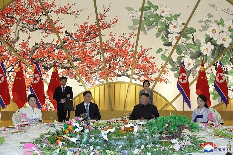 Chinese President Xi Jinping (second from left) and his wife Peng Liyuan (far left) with North Korean leader Kim Jong Un and his wife Ri Sol Ju during an official dinner on Thursday night. Mr Xi called the friendship between the two countries a share
