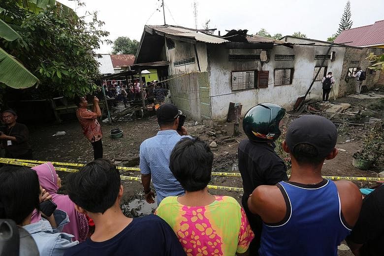 The remains of the house that was used as a factory producing lighters in Binjai town, North Sumatra, after a fire swept through it. Twenty-five workers - all women - and five children - four girls and one boy - died in the blaze. The factory's owner