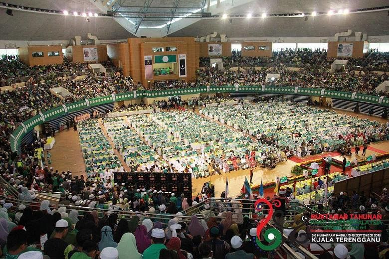 Delegates at the PAS annual assembly in Kuantan on Friday, with party president Abdul Hadi Awang on stage. The delegates were seated at the ground level, with observers and other party members on the higher level.
