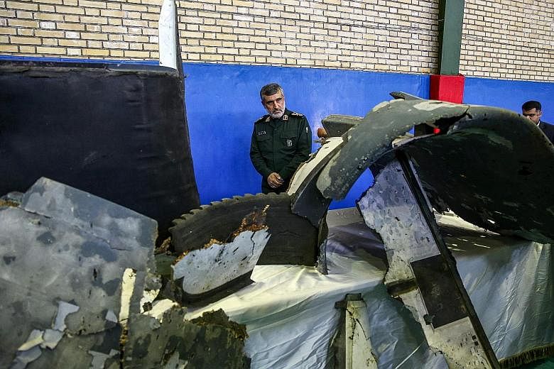 General Amir Ali Hajizadeh, head of Iran's Revolutionary Guard aerospace division, beside the debris from a downed US drone on display in Teheran last Friday. Iranian President Hassan Rouhani has accused the United States of stoking tensions in the G