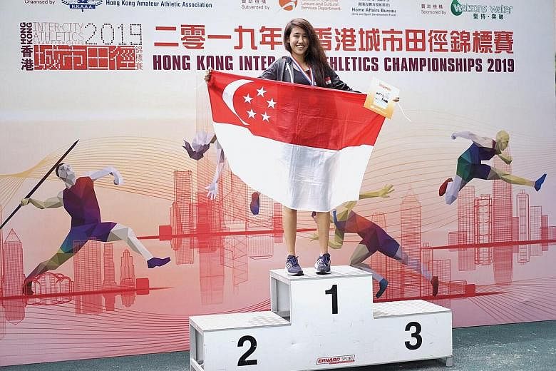 A proud Tia Louise Rozario holding the Singapore flag after she breaks the national triple jump record en route to winning the gold medal at the Hong Kong Inter-City Athletics Championships yesterday.