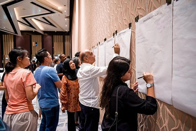Participants at yesterday's workshop scribbling down the biased notions that they have heard about certain groups of people. PHOTO: ONEPEOPLE.SG
