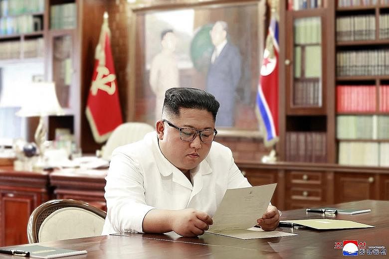 An undated photo released by North Korea's official Korean Central News Agency showing Mr Kim Jong Un reading a personal letter from US President Donald Trump. PHOTO: AGENCE FRANCE-PRESSE