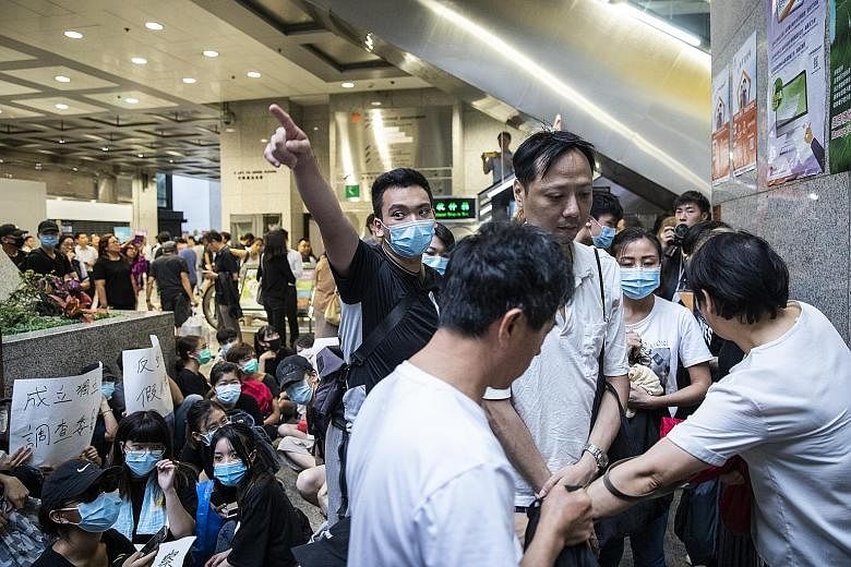 Protesters directing members of the public as they block an entrance inside Hong Kong's Revenue Tower during a demonstration against a controversial extradition Bill yesterday. The protesters are planning another demonstration tomorrow to raise aware