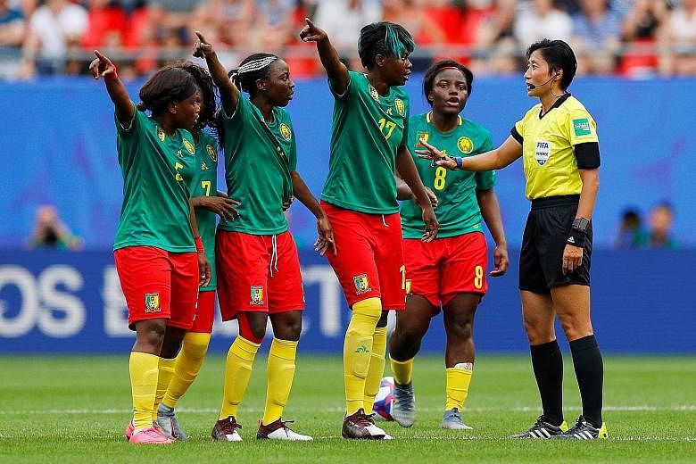 Cameroon's Gaelle Enganamouit (No. 17), Raissa Feudjio (No. 8) and teammates remonstrating with Chinese referee Liang Qin after England's second goal was awarded following a VAR review. They then appeared to threaten to walk off although this was ref