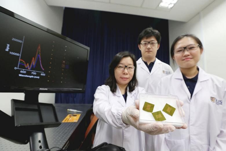 The NUS researchers (from far left) Assistant Professor Shao Huilin with doctoral students Zhang Yan and Carine Lim behind the test that can detect a molecule indicating early-stage Alzheimer's disease, the most common cause of severe dementia.