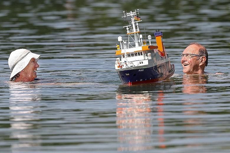 A couple cooling off in a lake at Schwarzachtalseen recreation centre in Ertingen, southern Germany, yesterday. The heatwave is the second to hit Europe this year.