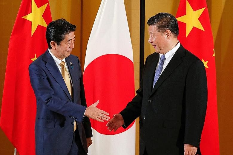 Japanese Prime Minister Shinzo Abe greeting Chinese President Xi Jinping at the start of their talks in Osaka yesterday, ahead of the G-20 Summit. PHOTO: AGENCE FRANCE-PRESSE