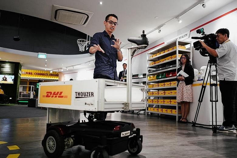 Marketing executive Kenneth Kok showing the use of a robotic trolley that can follow staff around yesterday at DHL Asia Pacific Innovation Centre, where the Connected Logistics Innovation Platform was launched.