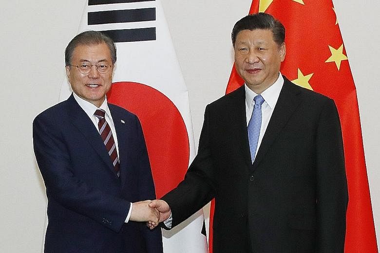South Korean President Moon Jae-in (left) and Chinese President Xi Jinping meeting before their talks in Osaka yesterday.