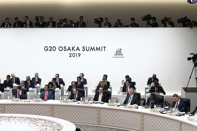 Prime Minister Lee Hsien Loong (front row, fourth from right) and Deputy Prime Minister Heng Swee Keat (behind PM Lee) at a meeting during the G-20 Summit in Osaka yesterday. An agreement to establish the Asian Development Bank's (ADB) new office in 