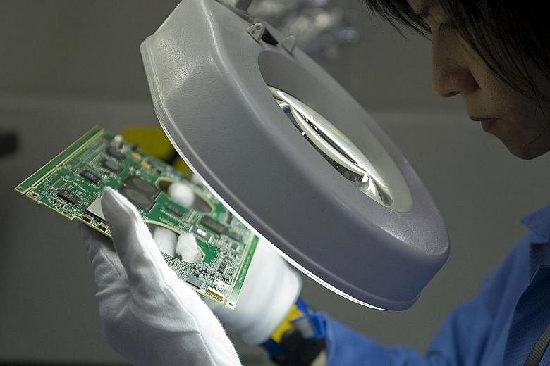 An assembly-line worker in a Venture Corp factory in Singapore. Firms such as Venture Corp that are in the supply chain for well-known global companies are worth tracking in the technology manufacturing sector.