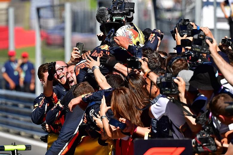 Max Verstappen celebrates with his team of Red Bull engineers after the Austrian Grand Prix in Spielberg yesterday. The Dutchman took the chequered flag for the first time this season after overtaking Charles Leclerc's Ferrari in the closing laps wit