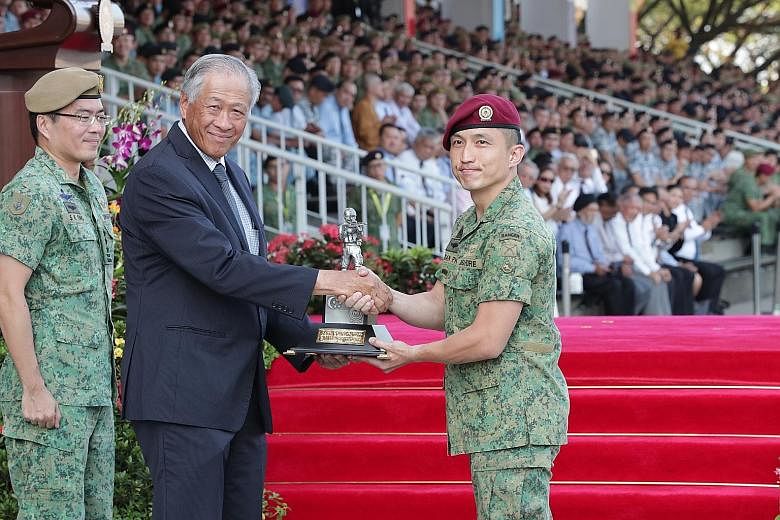 Lieutenant-Colonel Fabian Pwi (right), commanding officer of the 1st Commando Battalion, receiving the award for best unit from Defence Minister Ng Eng Hen during the Singapore Armed Forces Day Parade at the Safti Military Institute as the Chief of D