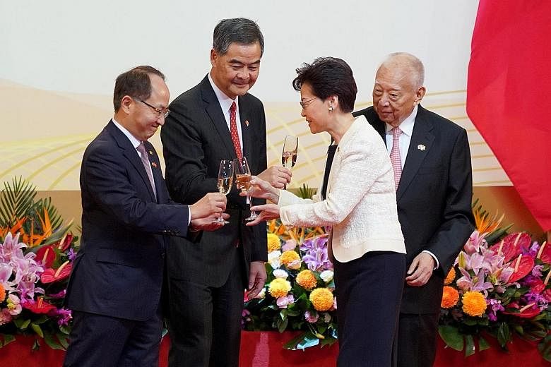 Hong Kong Chief Executive Carrie Lam raising a toast with (from left) Mr Wang Zhimin, director of China's Liaison Office in Hong Kong, and her predecessors Leung Chun Ying and Tung Chee Hwa, at the Convention and Exhibition Centre in Wanchai yesterda
