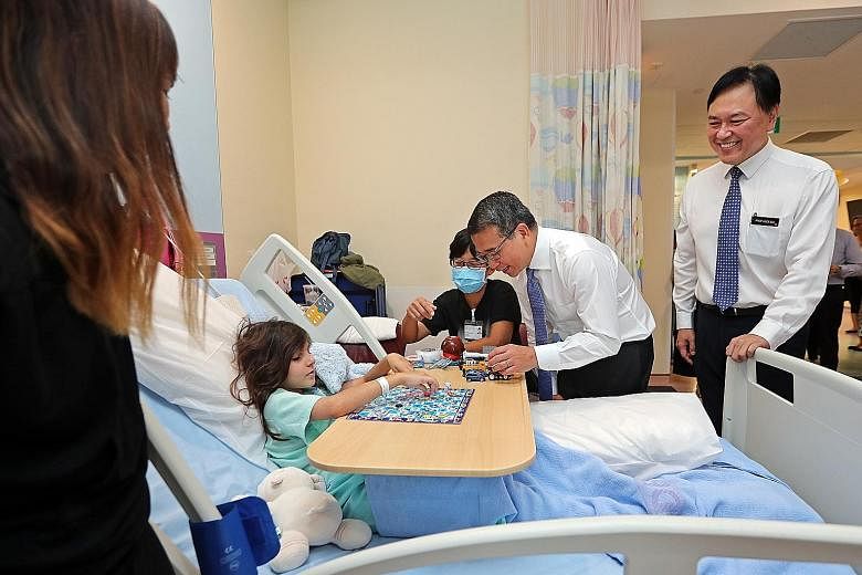 Senior Minister of State for Health Edwin Tong with Svea Nadia Hertzman, eight, at the children's ward of KK Women's and Children's Hospital (KKH) yesterday. He was accompanied by KKH chief executive Alex Sia.