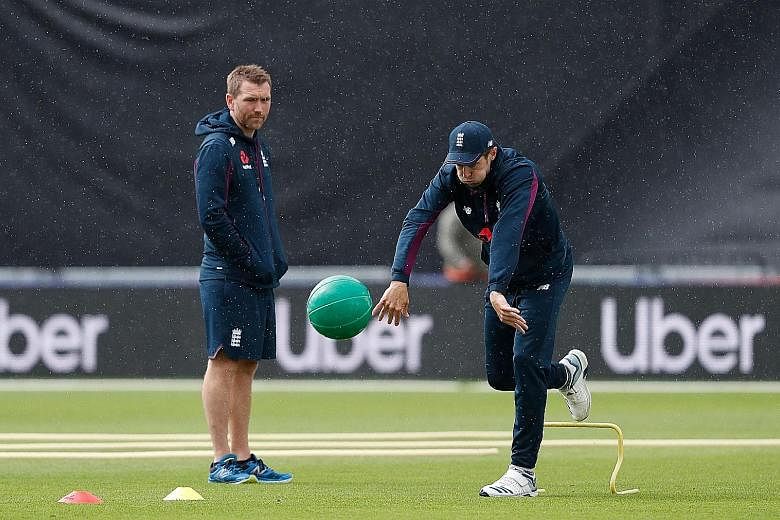 England all-rounder Chris Woakes throwing a medicine ball as a support staff member looks on during training last month at the Cricket World Cup. The top-ranked hosts are gunning for their first title.