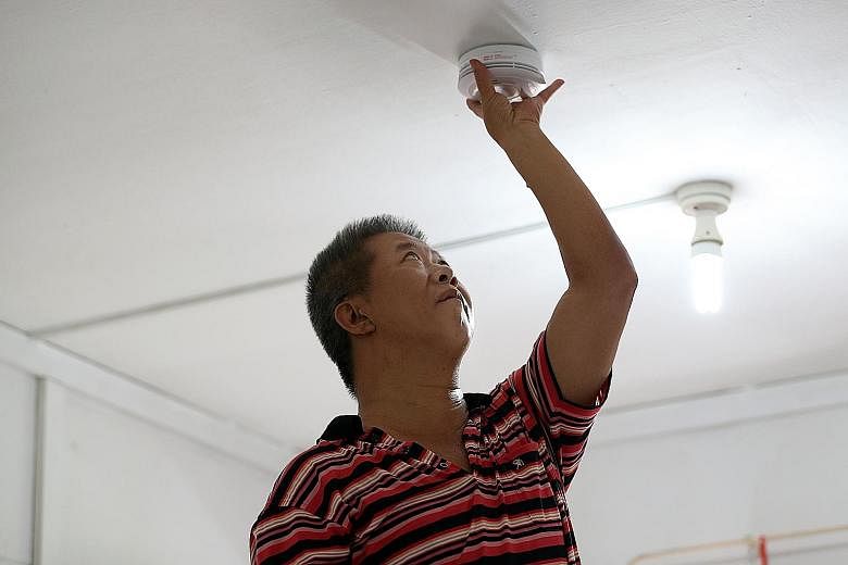 Above: Mr Gilroy Chan, 56, had the Home Fire Alarm Device installed in his rental flat as he believes in taking precautions. Right: Madam Marina Mohd Ali, 32, believes that the Home Fire Alarm Device will help ensure the safety of her children when t
