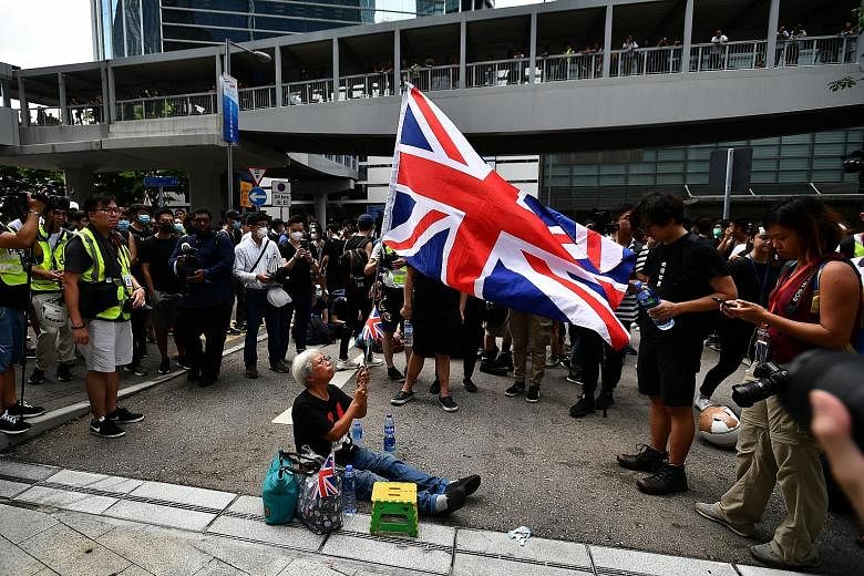 Ms Alexandra Wong has been on the front lines of protests. She is seen here waving the Union Jack at the entrance of the LegCo building on June 21.