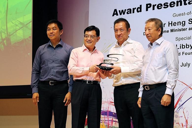 Above: Peter Lim handing out Singapore Olympic Foundation-Peter Lim Scholarship awards to recipients from the primary category at Temasek Polytechnic. Left: Deputy Prime Minister Heng Swee Keat giving Lim the IOC Trophy. With them are Speaker of Parl