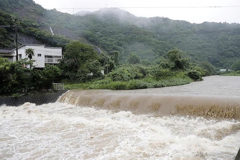 The Futami River swelling because of heavy rain in Yatsushiro, Kumamoto prefecture, in south-western Japan, yesterday. Many areas have seen more rain in a single day than in a typical month of July.