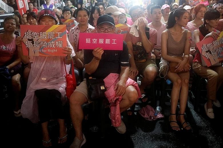 Eva Air flight attendants and their families at an event in Taipei on Tuesday to gather support for the strike, which started on June 20, over working conditions and wages. PHOTO: REUTERS